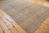 Vintage Distressed Khotan carpet showing worn texture, faded dusty teal, and pale mauve motif.