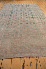 Distressed Khotan carpet with faded intricate panel motif and even wear in muted teal and mauve.