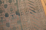 Khotan carpet detail showcasing geometric panel motifs, dusty teal and pale mauve low pile.