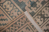 Distressed Khotan carpet corner with geometric panel motif in teal, mauve, and secured side.