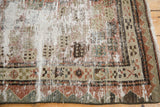 Close-up of distressed Malayer runner, showing exposed foundation and primitive man harvesting motif.