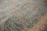 Decorative distressed texture of sky blue and blush scrolling vinery with mil fleur motifs.