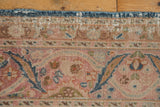 Meshed rug edge detail: sky blue selvage, pale blush, curvilinear motifs, and visible wear.