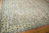 Corner detail of distressed vintage Arak carpet, highlighting worn blush, ivory, navy floral patterns.