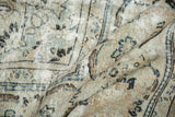Distressed texture and worn floral patterns on a vintage Arak carpet in blush and navy.