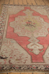 Vintage Distressed Oushak rug with faded blush, antique ivory rococo leaves, and textured wear.