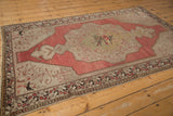 Distressed Oushak rug: faded cochineal, Rococo leaves, and intact side cord selvage.