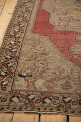 Distressed Oushak rug's patterned border and worn pile with faint foundation.