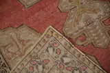 Close-up of the hand knotted Oushak rug's tight reverse weave and distressed reddish pile.