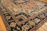 Antique Serapi rug's navy border with pale terra cotta geometric and floral motifs.