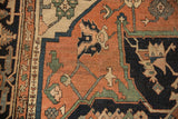 Antique Serapi carpet detail showing geometric vinery and floral motifs in terra cotta, navy, and green.