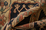 Folded antique Serapi rug, hand-knotted pile, geometric vinery in navy, terra cotta, beige.