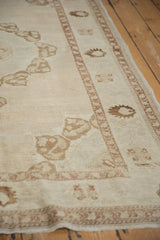 Vintage distressed Oushak rug's textured surface, with germinating plant motifs and mostly even wear.