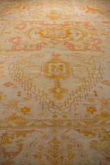 Saffron yellow and pale terracotta serrated patterns on an antique Oushak rug.