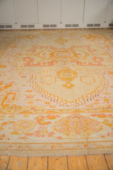 Antique Oushak carpet border, showing wide terra cotta, lemon patterns, subtle wear, pale fringe.