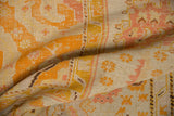 Close-up of antique Oushak rug pile showing wear and saffron serrated patterns.
