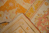Antique Oushak rug's hand-knotted pile, woven foundation, and secured orange selvage.