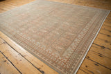 Border detail of distressed Sivas rug with muted terra cotta boteh and floral patterns.