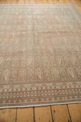 Distressed Sivas carpet detail with ivory, dusty terra cotta allover boteh, and geometric border.