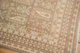 Distressed vintage Sivas carpet corner, displaying geometric borders and muted botanical patterns.