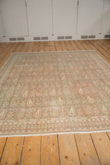 Soft, distressed pile of a vintage Sivas rug with ivory and terra cotta boteh patterns.