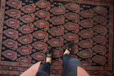 Vintage Persian Senneh rug displaying allover boteh design in navy, red, and blue with varied pile.