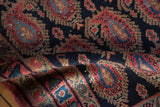 Folded vintage Persian Senneh rug pile with navy, red, and blue boteh pattern.