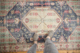 Distressed hand-knotted Turkish Sparta rug, showcasing worn dark denim blue and pale red motifs.