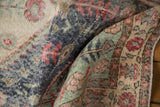 Worn pile of vintage Sparta rug, showing distressed denim blue, mint, and red motifs.
