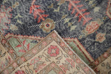Distressed hand knotted Turkish Sparta rug corner with denim blue field, red motifs, and visible foundation.