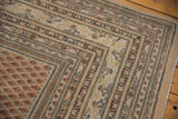 Distressed vintage Mir Sarouk rug corner with intricate borders and muted field patterns in beige, terracotta.