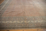 Distressed Mir Sarouk rug corner showing delicate boteh design and worn texture.