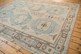Powder blue and dark brown geometric border and field medallions on an Afghani Soumac rug.