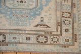 Afghani Soumac flatweave corner with powder blue, ivory, and brown geometric patterns.
