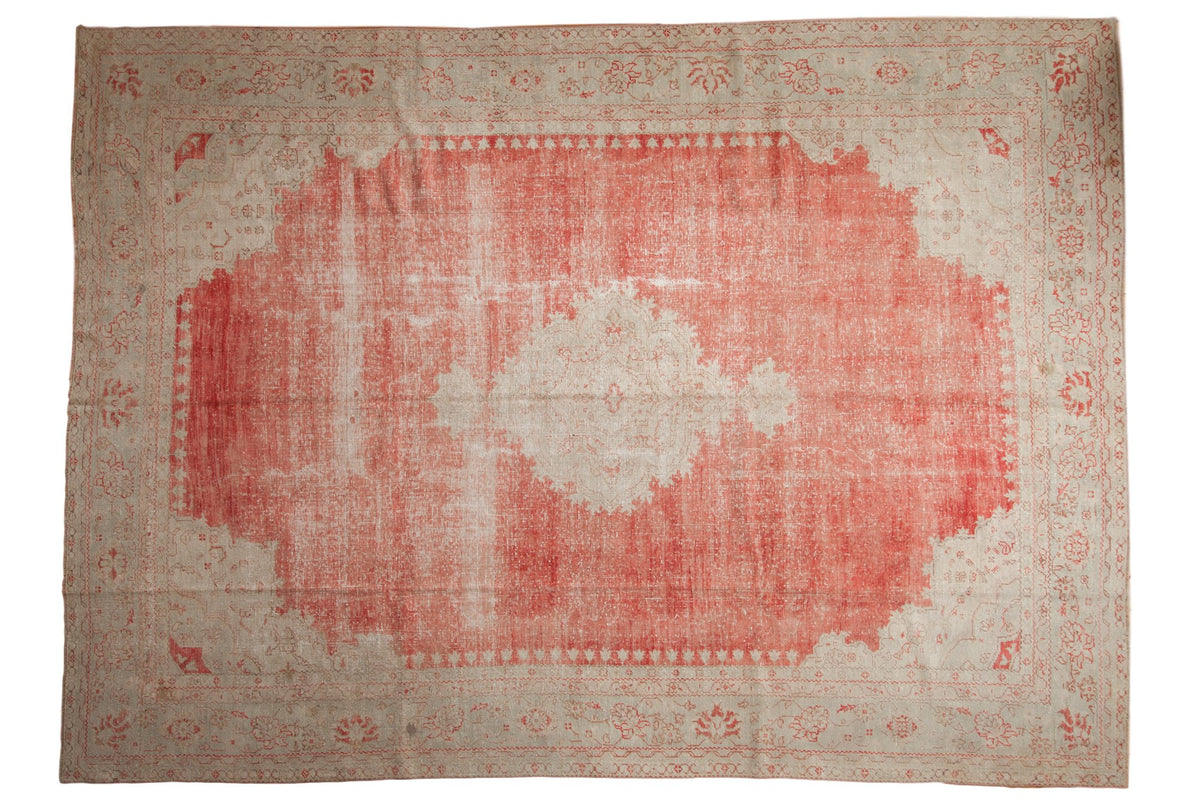 Distressed vintage Oushak carpet in faded cherry red and ivory with a large scalloped central medallion.