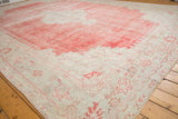 Corner spandrel detail of a distressed Oushak rug in faded cherry red and ivory tones.