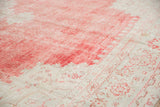 Worn texture and visible knot heads on a distressed Oushak carpet in faded red and ivory.