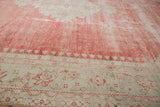 Distressed low pile and meandering floral border of a vintage Turkish Oushak carpet.
