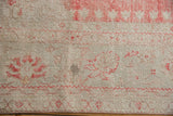 Worn texture of a distressed Oushak carpet with faded red motifs and visible knot heads.