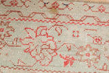 Worn pile of a vintage Oushak carpet with faded red floral cross-section motifs.