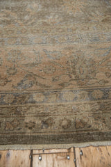 Textured wear of a vintage distressed Sparta carpet, with muted olive and beige floral motifs.