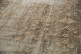 Detail of vintage Sparta carpet with worn texture, dusty green floral motifs, and visible knot heads.