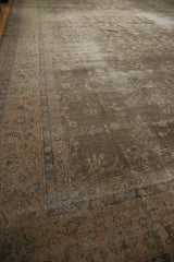 Distressed vintage Sparta carpet showing muted floral blossom motif and worn pile.