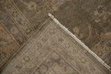 Distressed vintage Sparta carpet corner showing muted floral pile, woven foundation, and fringe.