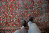 Brick red field of Mahal rug, allover floral vinery, and visible wear across pile.