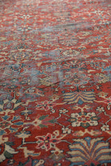 Vintage Mahal carpet detail with brick red floral motifs and visible foundation wear.