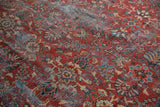 Vintage Mahal carpet detail with brick red field, worn floral blossom and vine motifs; areas show visible foundation.