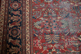 Detail of vintage Mahal rug's brick red floral field, colorful vinery, and visible foundation.