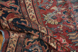 Folded vintage Mahal rug's textured pile, showing brick red, navy, beige floral blossom motifs.