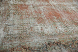Distressed vintage Mahal carpet's textured surface with blush, ivory, and seafoam motifs.